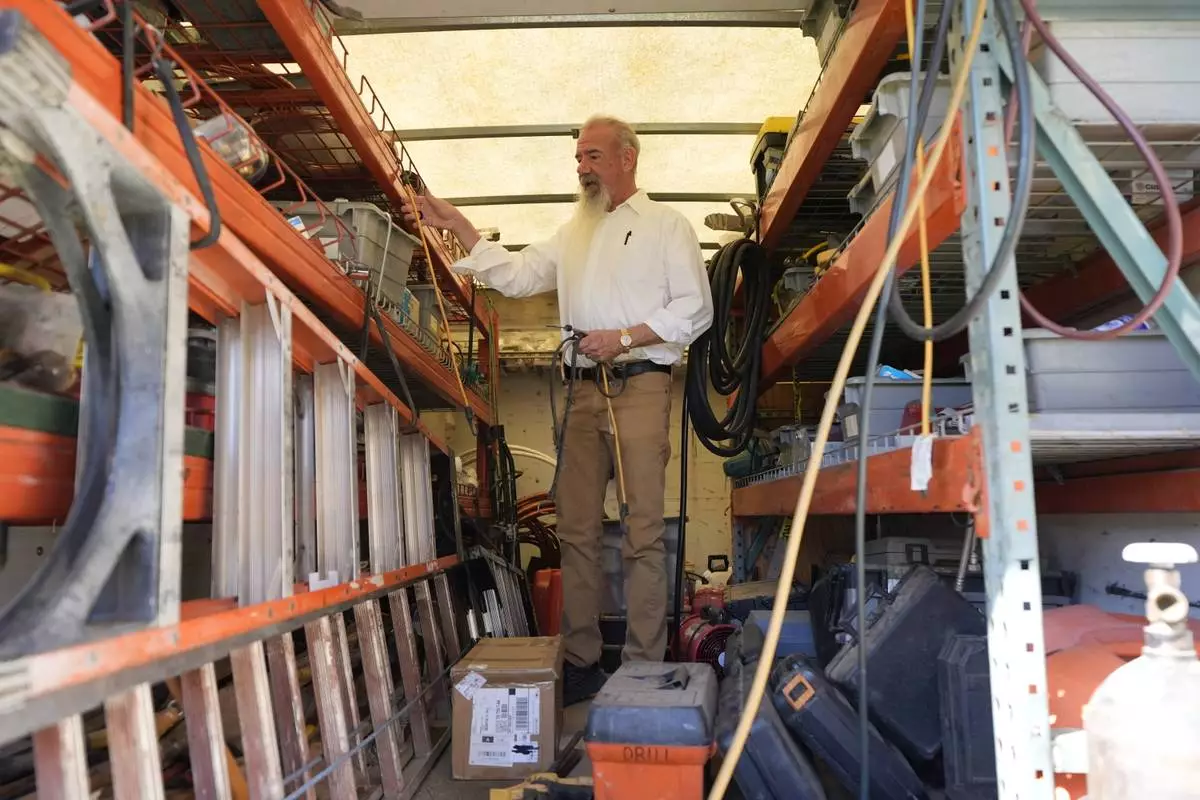 Matthew Haines, owner of the Oakwood Apartments, collects tools from the back of his work truck as he performs maintanence at the comminty housing location in Arlington, Texas, Tuesday, March 17, 2026. (AP Photo/Tony Gutierrez)