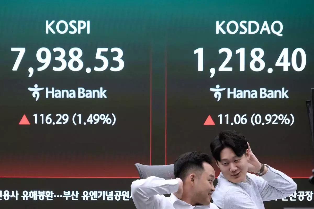 Currency traders react near a screen showing the Korea Composite Stock Price Index (KOSPI), left, at the foreign exchange dealing room of the Hana Bank headquarters in Seoul, South Korea, Tuesday, May 12, 2026. (AP Photo/Ahn Young-joon)