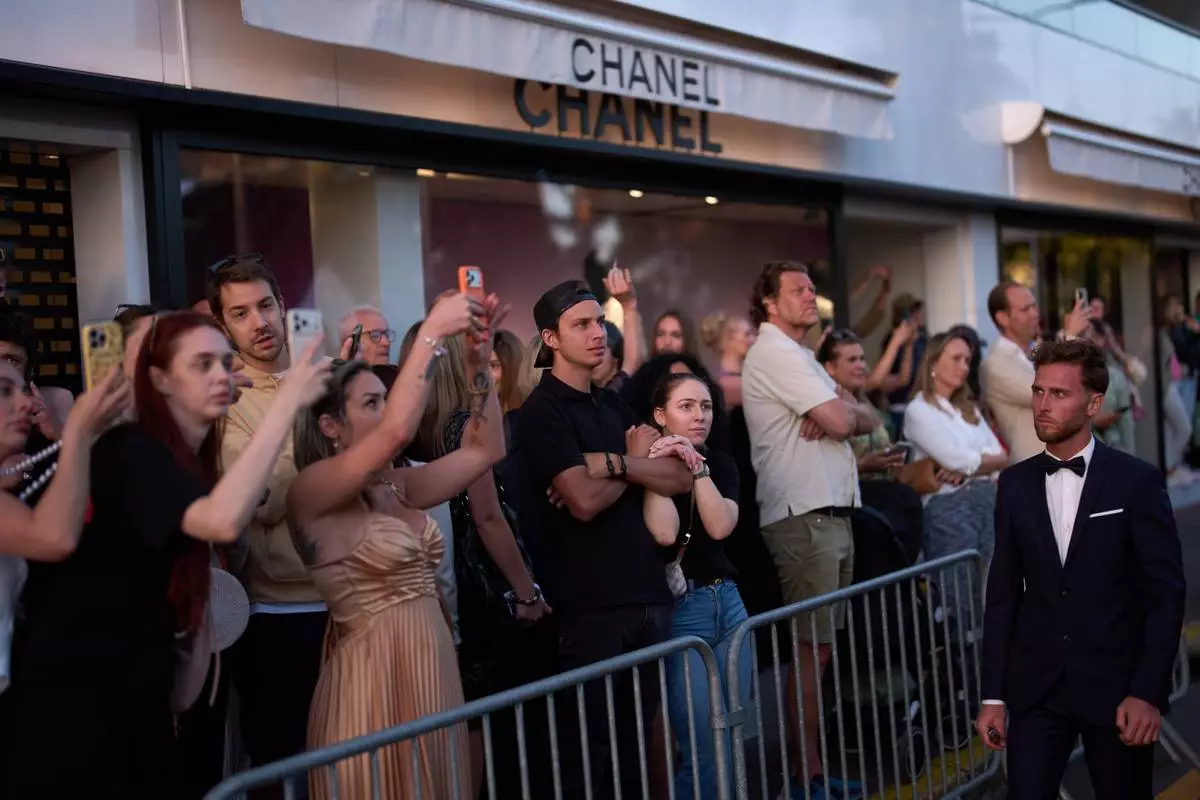 People try to catch a glimpse of celebrities on the red carpet during the 79th international film festival, Cannes, southern France, Wednesday, May 13, 2026. (AP Photo/John Locher)