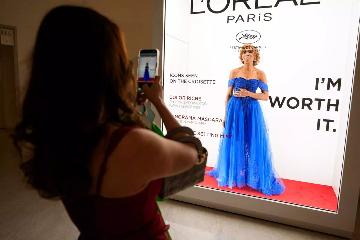 A woman poses for a friend in the Hotel Martinez during the 79th international film festival, Cannes, southern France, Tuesday, May 19, 2026. (AP Photo/Andreea Alexandru)