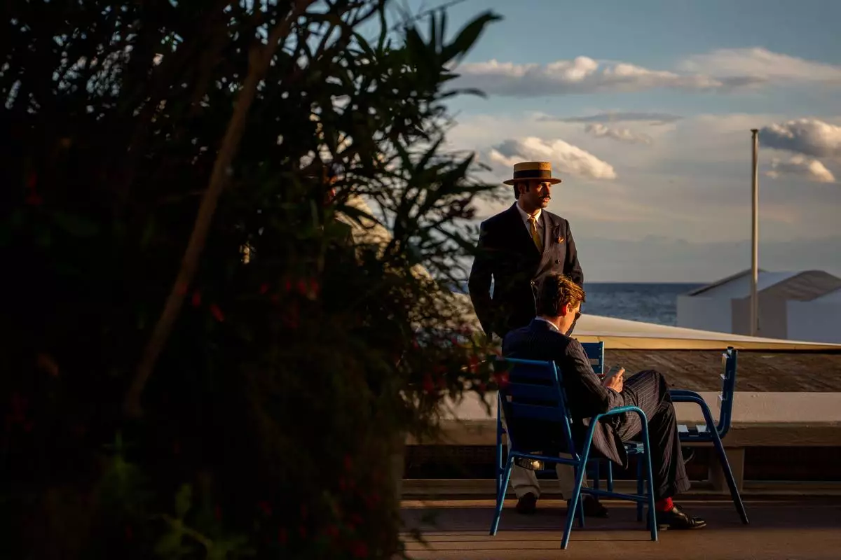 Men relax at sunset on the Boulevard de la Croisette during the 79th international film festival, Cannes, southern France, Thursday, May 14, 2026. (AP Photo/Andreea Alexandru)