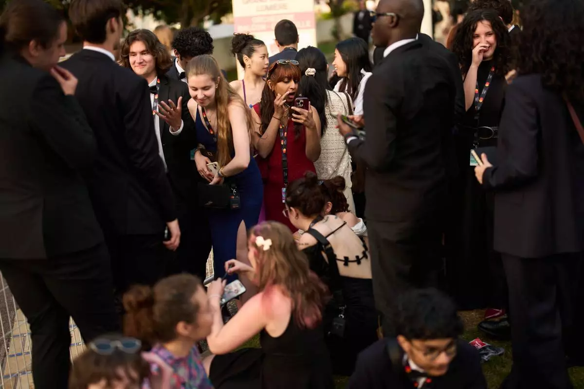 Festivalgoers get ready as they wait in line before the 79th international film festival, Cannes, southern France, Sunday, May 17, 2026. (AP Photo/John Locher)