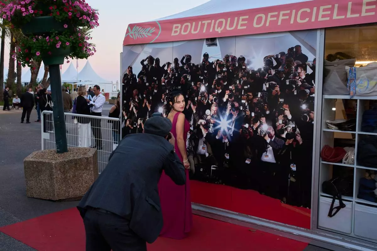 Festivalgoers pose in front of a backdrop during the 79th international film festival, Cannes, southern France, Wednesday, May 13, 2026. (AP Photo/John Locher)
