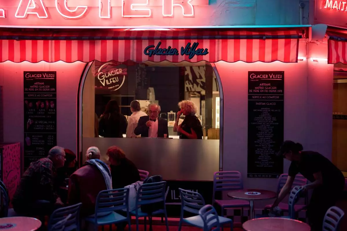 Festivalgoers eat at an ice cream shop near the 79th international film festival, Cannes, southern France, Sunday, May 17, 2026. (AP Photo/John Locher)