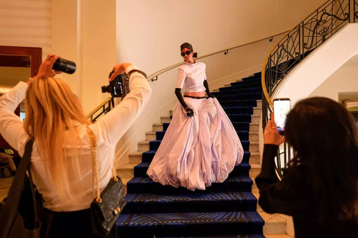 A woman poses for photographers in the Hotel Martinez during the 79th international film festival, Cannes, southern France, Tuesday, May 19, 2026. (AP Photo/Andreea Alexandru)