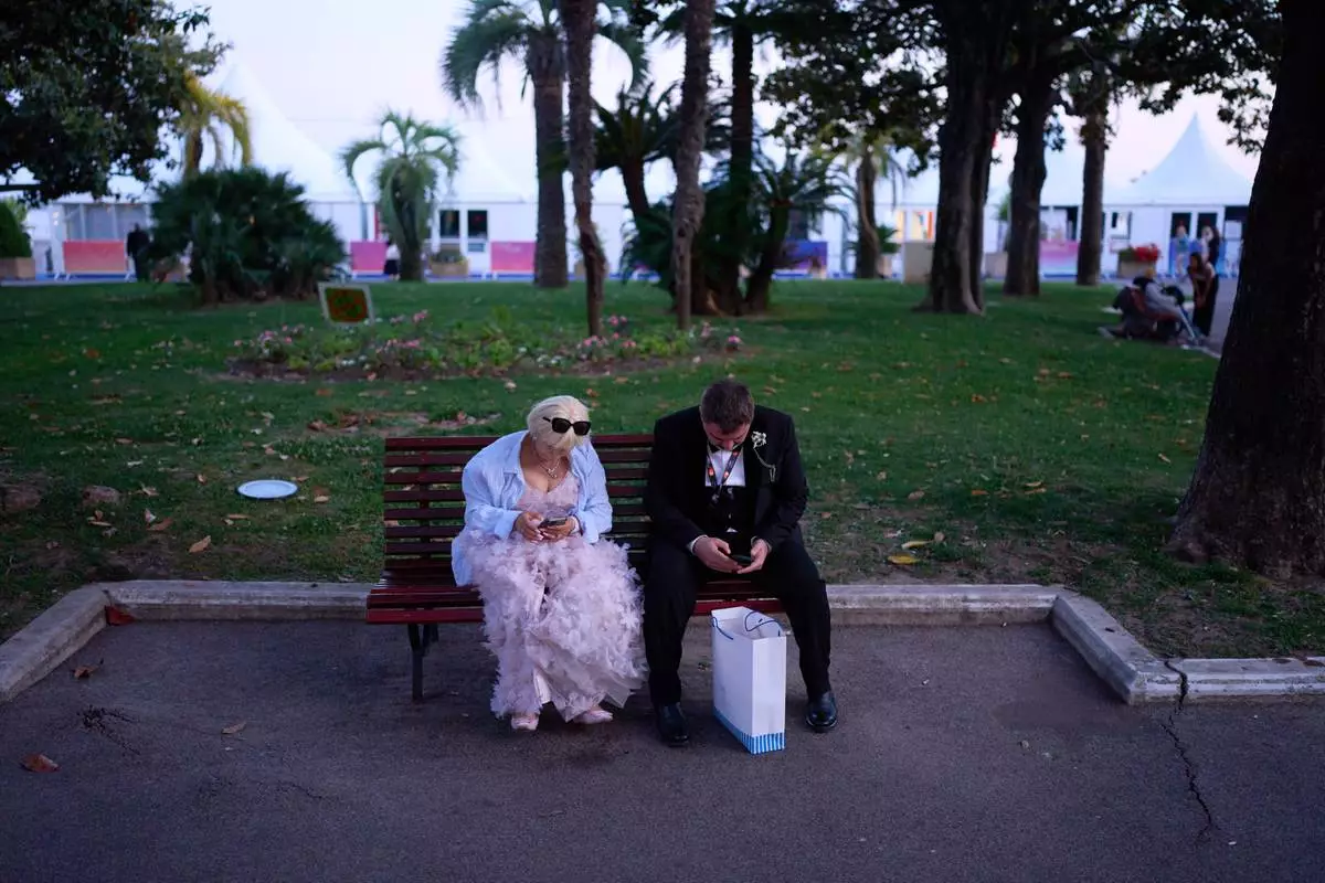 Festivalgoers wait in a park near the 79th international film festival, Cannes, southern France, Wednesday, May 13, 2026. (AP Photo/John Locher)