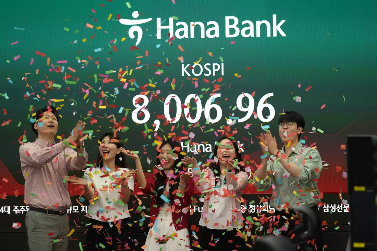 Employees of Hana Bank celebrate in a photo-op to mark the Korea Composite Stock Price Index (KOSPI) of over 8,000 points at a dealing room of Hana Bank in Seoul, South Korea, Friday, May 15, 2026. (AP Photo/Lee Jin-man)