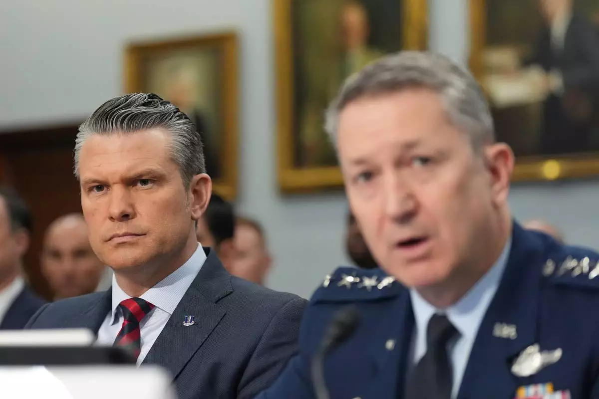 Defense Secretary Pete Hegseth watches as Chairman of the Joint Chiefs of Staff Gen. Dan Caine testifies at a House Appropriations subcommittee budget hearing for the Department of Defense, Tuesday, May 12, 2026, in Washington. (AP Photo/Alex Brandon)