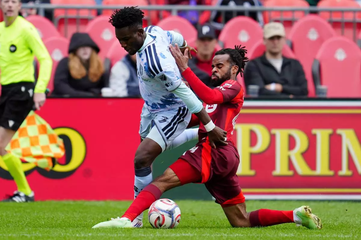 Toronto FC defender Raheem Edwards, right, tackles San Jose Earthquakes forward Ousseni Bouda (7) during the first half of an MLS soccer game in Toronto, Saturday, May 2, 2026. (Frank Gunn/The Canadian Press via AP)
