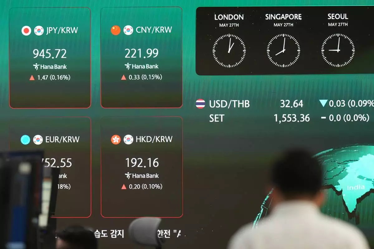 A dealer walks past near the screens showing the foreign exchange rates at a dealing room of Hana Bank in Seoul, South Korea, Wednesday, May 27, 2026. (AP Photo/Lee Jin-man)