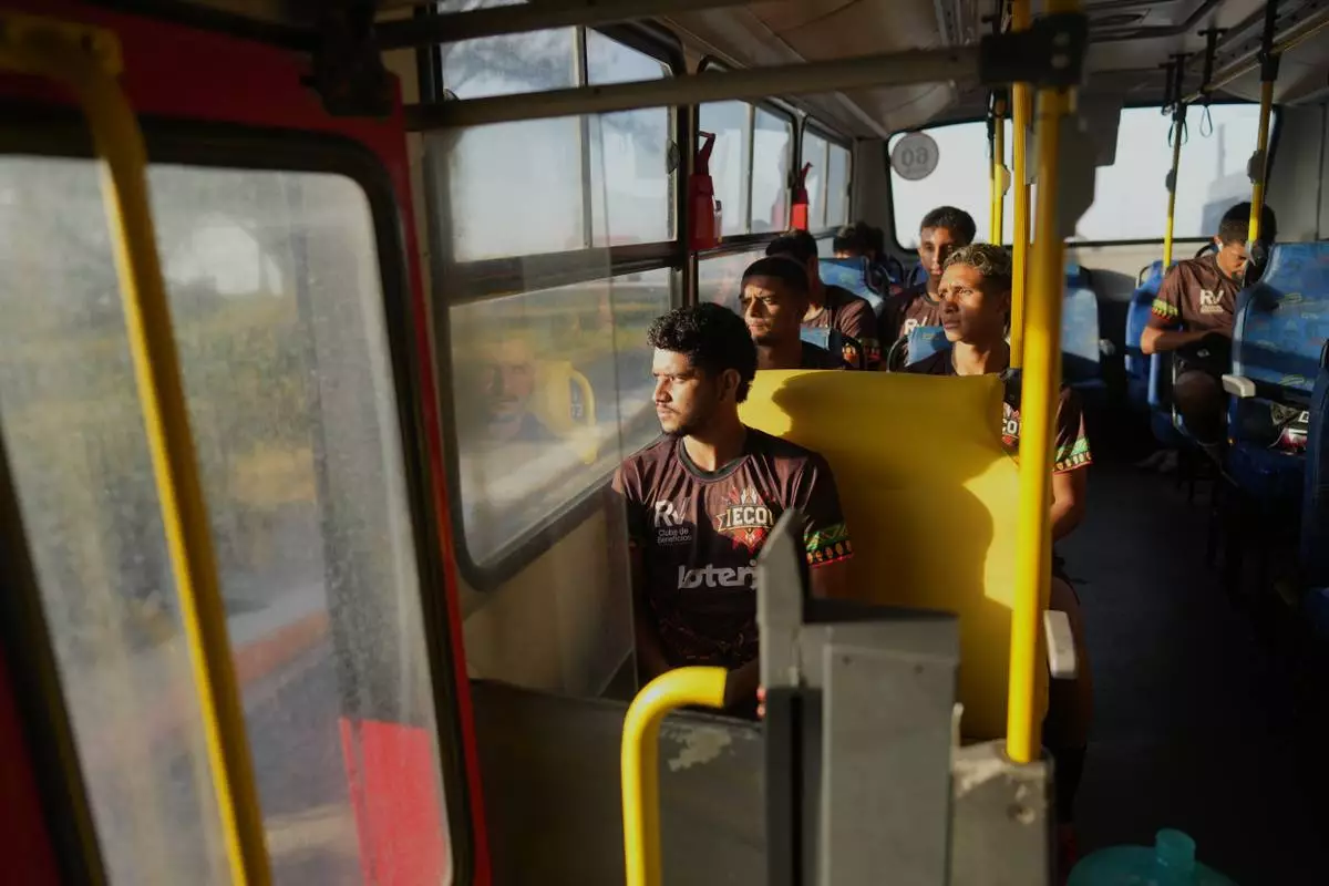 FILE - Players of Originarios, a new soccer team in Rio's fifth division made up exclusively of Indigenous players, ride a bus to practice in Marica, Brazil, April 28, 2026. (AP Photo/Silvia Izquierdo, File)