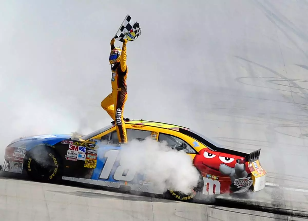 FILE - Kyle Busch celebrates his win in the NASCAR Sprint Cup Series' Autism Speaks 400 auto race, Sunday, May 16, 2010, in Dover, Del. (AP Photo/Nick Wass, File)