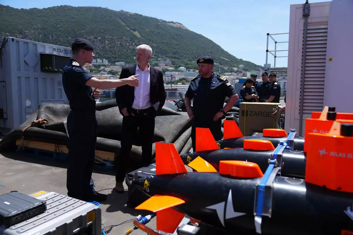 Britain's Armed Forces Minister Al Carns, centre, inspects autonomous vehicles with sonar sensor that can detect and identify mines, on RFA Lyme Bay, in British Overseas Territory of Gibraltar, on Friday, May 22, 2026. (AP Photo/Kwiyeon Ha) CORRECTION: Location corrected to British Overseas Territory of Gibraltar, instead of territory of Gibraltar