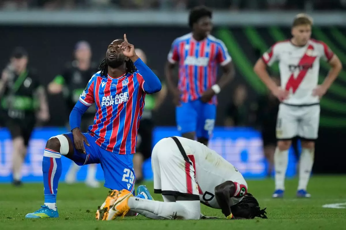 Crystal Palace's Evann Guessanda celebrate next to Rayo's Pathe Ciss after the Europa Conference League final soccer match between Crystal Palace and Rayo Vallecano in Leipzig, Germany, Wednesday, May 27, 2026. (AP Photo/Ebrahim Noroozi)