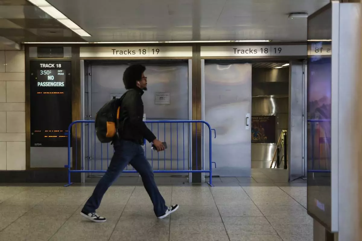 A pedestrian walks past closed off tracks inside Penn Station on the first day of a Long Island Rail Road strike, Saturday, May 16, 2026, in New York. (AP Photo/Heather Khalifa)