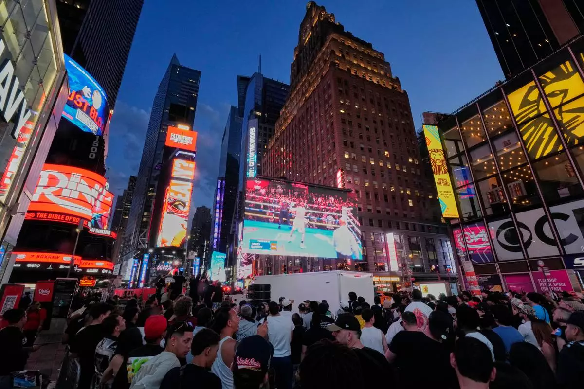 FILE - People gather in Times Square to watch a boxing match, May 2, 2025, in New York. (AP Photo/Frank Franklin II, File)