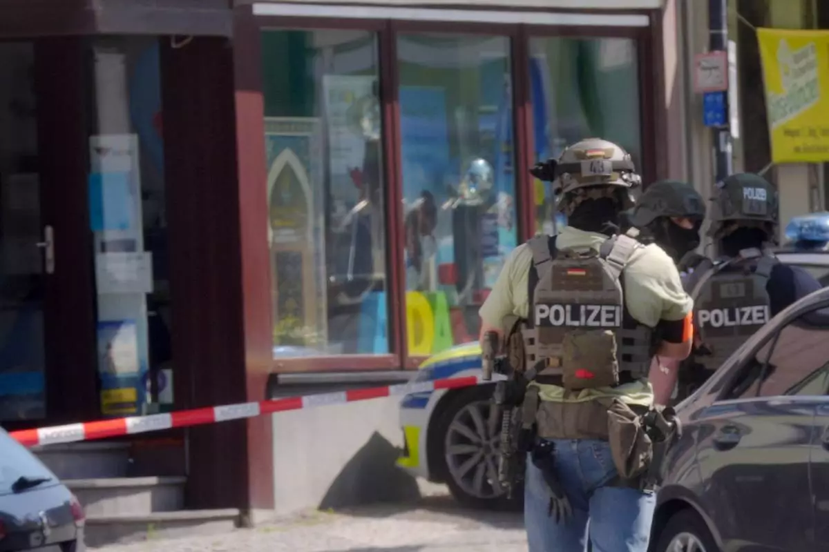 Police officers stand at the scene of an incident where, according to reports, a hostage situation has occurred at a bank branch in Sinzig, Germany, Friday, May 8, 2026. (Thomas Frey/dpa via AP)