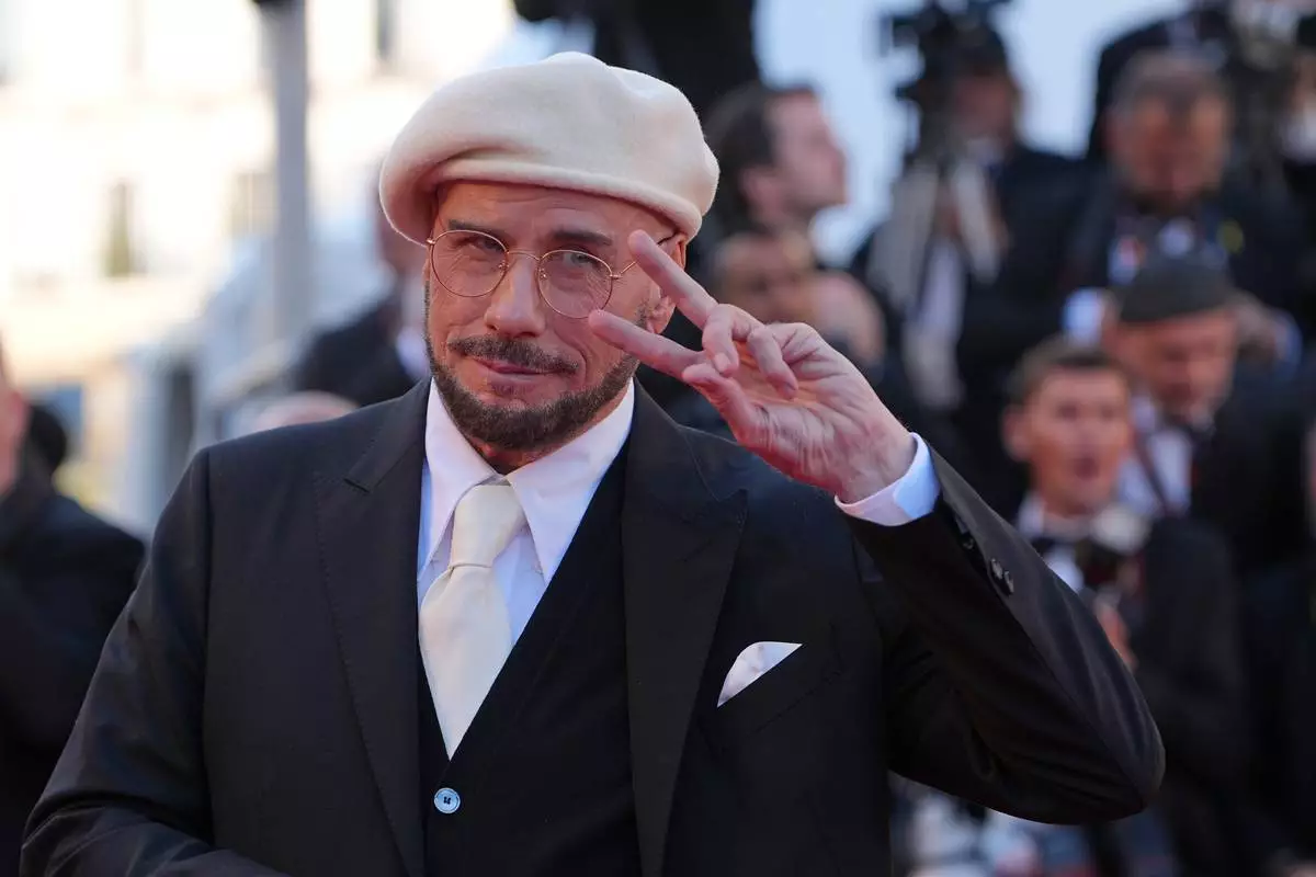 John Travolta poses for photographers upon arrival at the premiere of the film 'Karma' at the 79th international film festival, Cannes, southern France, Friday, May 15, 2026. (AP Photo/Andreea Alexandru)