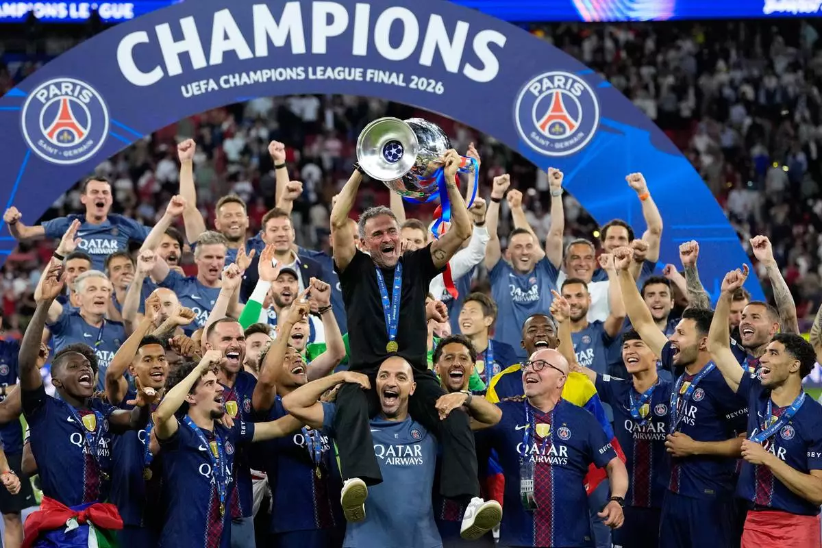 PSG's head coach Luis Enrique lifts the trophy celebrating after winning the Champions League final soccer match between Paris Saint-Germain and Arsenal in Budapest, Hungary, Saturday, May 30, 2026. (AP Photo/Petr Josek)
