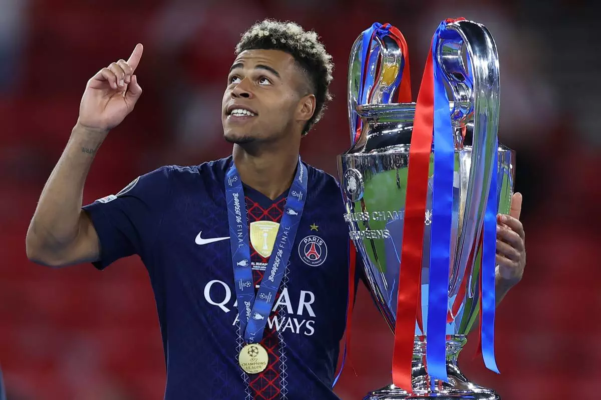 PSG's Desire Doue holds the trophy after the Champions League final soccer match between Paris Saint-Germain and Arsenal in Budapest, Hungary, Saturday, May 30, 2026. AP Photo/Armin Durgut)