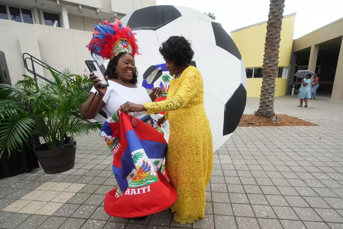 Guensine Ambo, left, dances at a Haitian Heritage Month event featuring the Haiti national soccer team, Saturday, May 30, 2026, in North Miami, Fla., ahead of the FIFA World Cup soccer tournament. (AP Photo/Lynne Sladky) CORRECTION: Corrects to Guensine Ambo, left, not right.