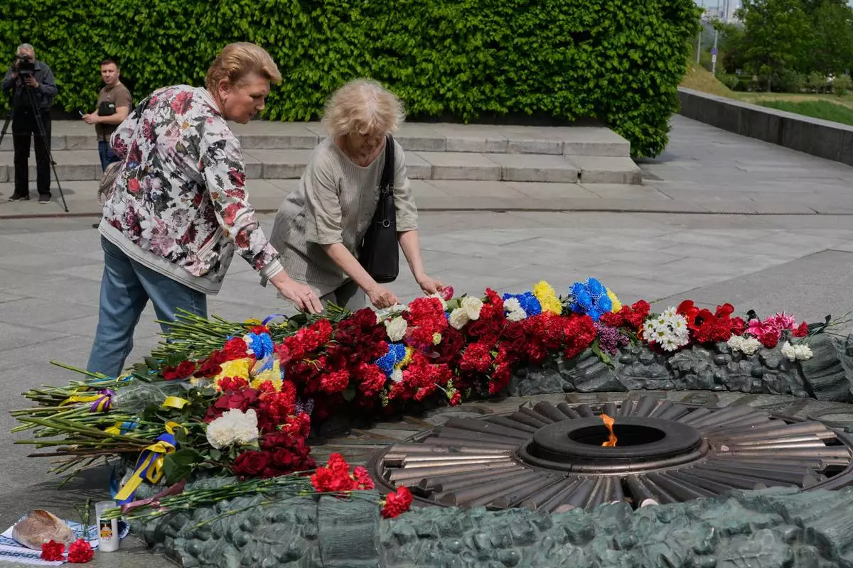 People lays flowers to the monument of the Unknown Soldier to mark Victory Day in World War II, in Kyiv, Ukraine, Tuesday, May 8, 2026. (AP Photo/Efrem Lukatsky)
