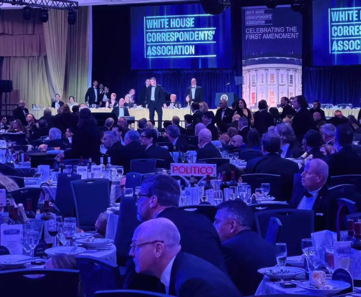 FILE - U.S. Secret Service agents respond near President Donald Trump and first lady Melania Trump during the White House Correspondents Dinner, Saturday, April 25, 2026, in Washington. (AP Photo/Alex Brandon, File)