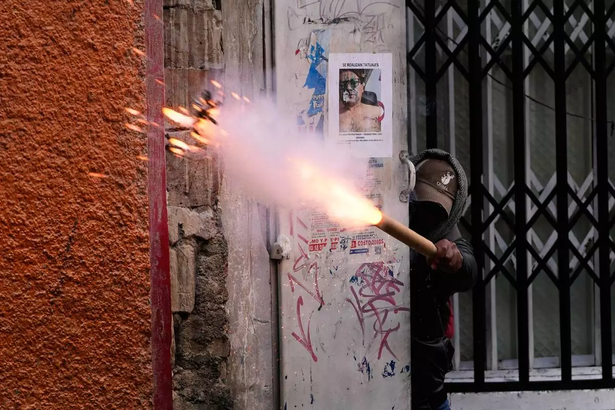 A demonstrator launches a firecracker at police during an anti-government protest in La Paz, Bolivia, Friday, May 22, 2026. (AP Photo/Juan Karita)