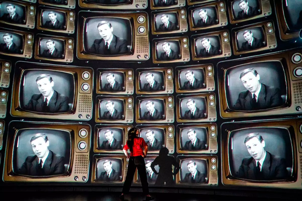 FILE - Head of creative enterprise, Maddie Hall, watches hundreds of television screens with broadcaster and naturalist David Attenborough's face, from when he was a young broadcaster, projected on a 360 degree screen inside the dome within the Market Hall ahead of a public release of an immersive film to mark his 100th birthday on May 8, at Real Ideas in Devonport, Plymouth, England, May 6, 2026. (Ben Birchall/PA via AP, File)