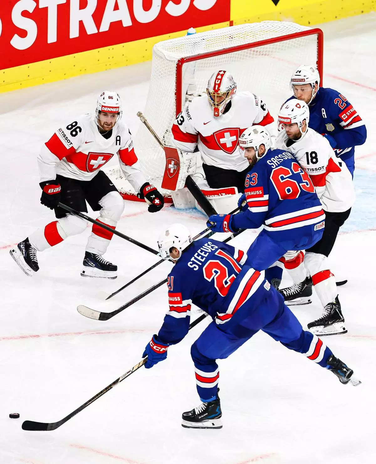 USA's Alex Steeves, bottom, prepares to shoot an score during a Group A preliminary round game between United States and Switzerland at the men's ice hockey world championship in Zurich, Switzerland, Friday, May 15, 2026. (Michael Buholzer/Keystone via AP)