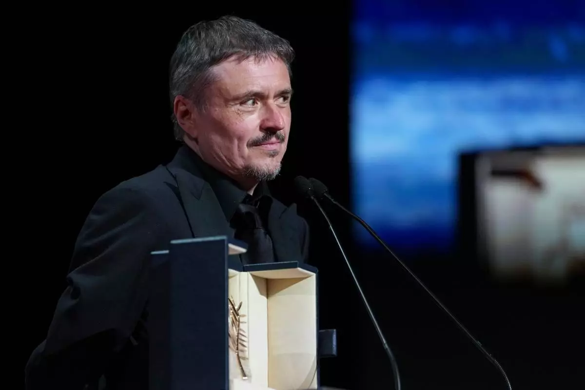 Cristian Mungiu accepts the Palme d'Or for 'Fjord' during the awards ceremony at the 79th international film festival, Cannes, southern France, Saturday, May 23, 2026. (AP Photo/Andreea Alexandru)