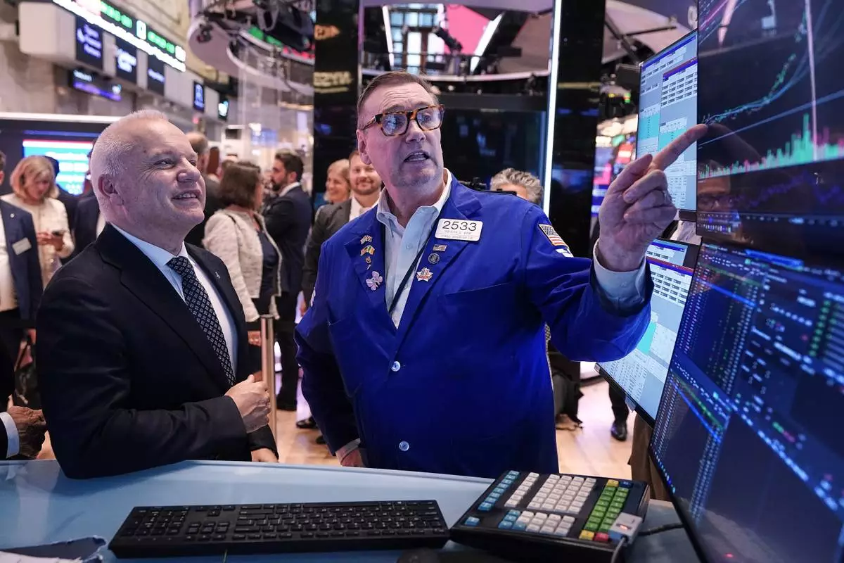 Anders Opedal, President and CEO of Norway's Equinor, left, meets with specialist Patrick King on the floor of the New York Stock Exchange, after he rang the closing bell, Tuesday, June 16, 2026. (AP Photo/Richard Drew)
