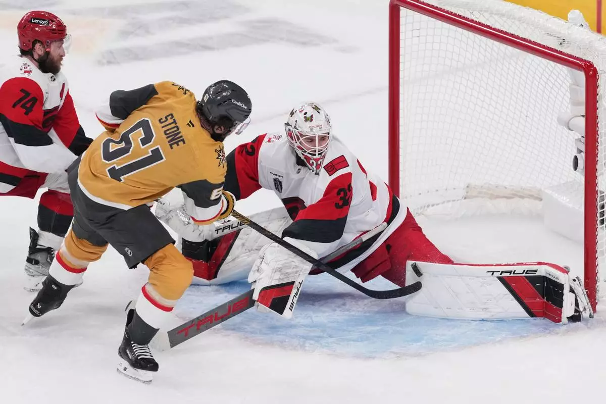 Carolina Hurricanes goaltender Brandon Bussi (32) stops a shot from Vegas Golden Knights right wing Mark Stone (61) during the first period in Game 6 of the NHL hockey Stanley Cup Final series, Sunday, June 14, 2026, in Las Vegas. (AP Photo/Candice Ward)