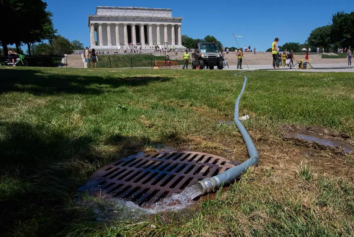 Water is pumped out of the Lincoln Memorial Reflecting Pool as it is cleaned of algae, Tuesday, June 16, 2026, in Washington. (AP Photo/Jacquelyn Martin)
