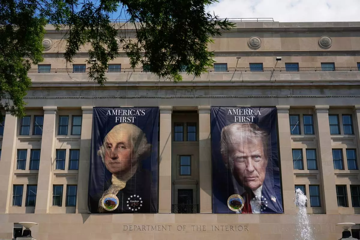 Banners, one of President George Washington that reads "America's First," left, and another of President Donald Trump that reads, "America First," are pictured at the Department of the Interior, Thursday, June 25, 2026, in Washington. (AP Photo/Carolyn Kaster)
