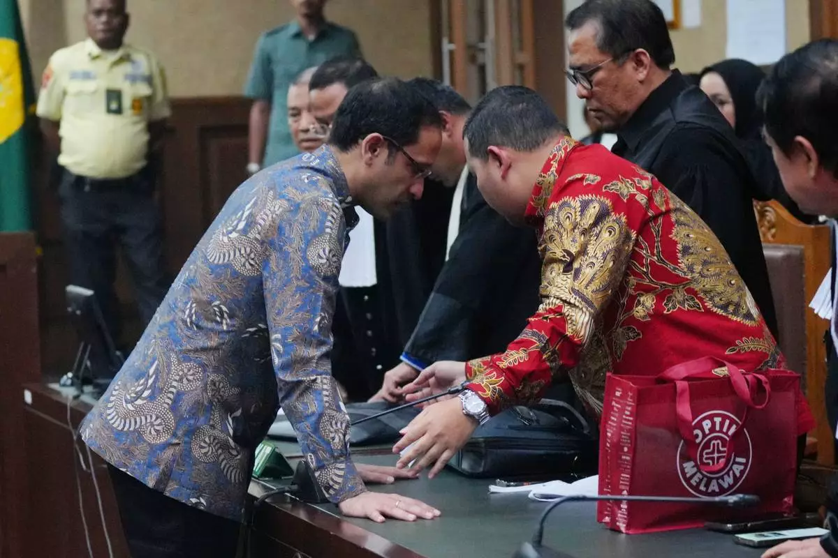 The co-founder of ride-hailing and payment giant Gojek and fomer Indonesian Education Minister Nadiem Anwar Makarim, left, speaks with his lawyers after being sentenced in a Google Chromebook laptop procurement corruption case, at the Corruption Court in Jakarta, Indonesia, Tuesday, June 30, 2026. (AP Photo/Tatan Syuflana)