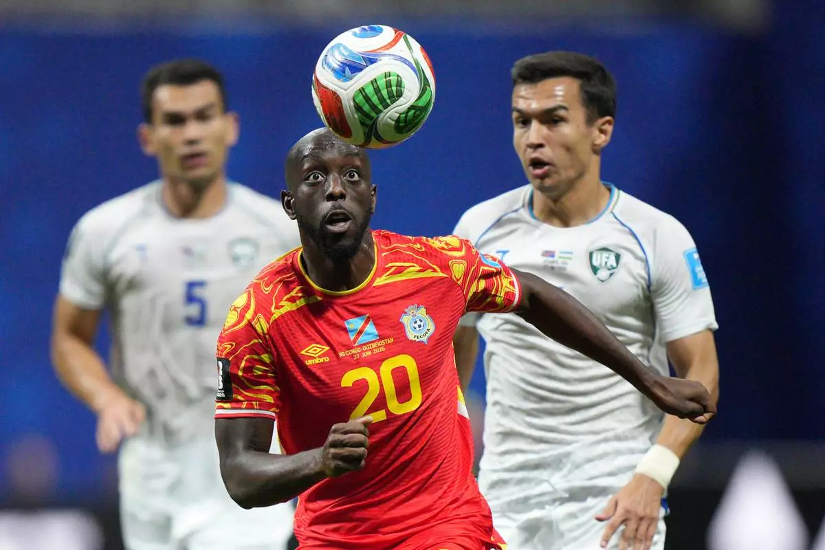 Congo's Yoane Wissa (20) runs after the ball as Uzbekistan's Otabek Shukurov, right, and Rustam Ashurmatov (5) look on during the first half of the World Cup Group K soccer match between DR Congo and Uzbekistan in Atlanta, Saturday, June 27, 2026. (AP Photo/Jacob Kupferman)