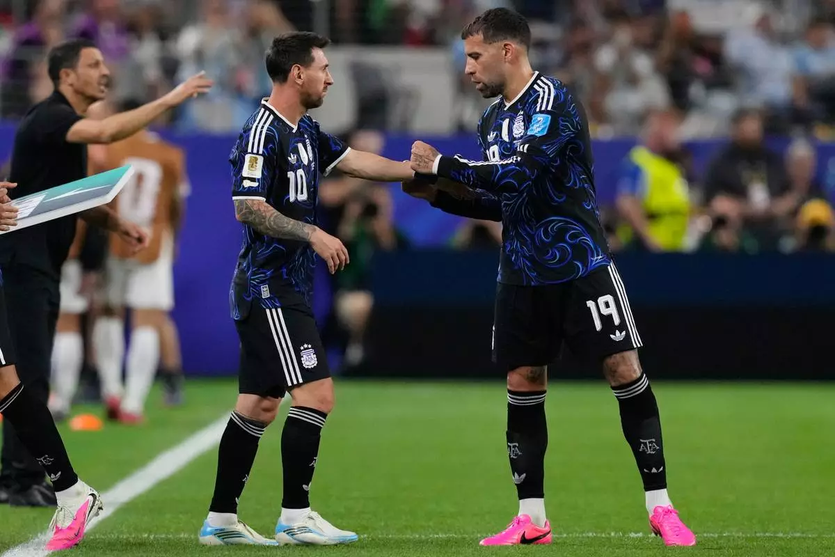 Argentina's Nicolas Otamendi (19) gives the captain's armband to Lionel Messi (10) during the World Cup Group J soccer match between Jordan and Argentina in Arlington, Texas, near Dallas, Saturday, June 27, 2026. (AP Photo/Tony Gutierrez)