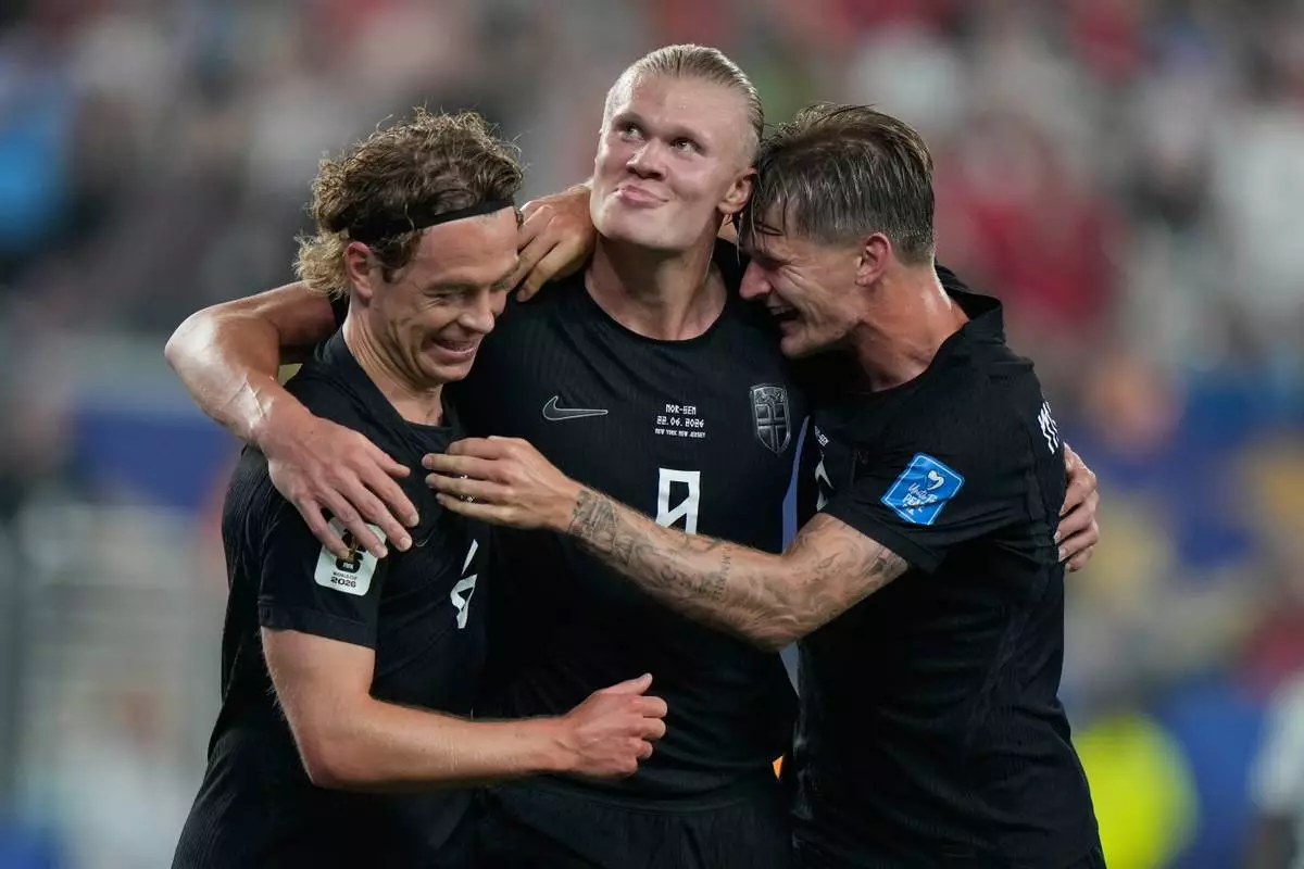 Norway's Erling Haaland (9) celebrates Norway's Patrick Berg, left, and David Moeller Wolfe, right after scoring their third goal during the World Cup Group I soccer match between Norway and Senegal in East Rutherford, N.J., near New York, Monday, June 22, 2026. (AP Photo/Steve Luciano)