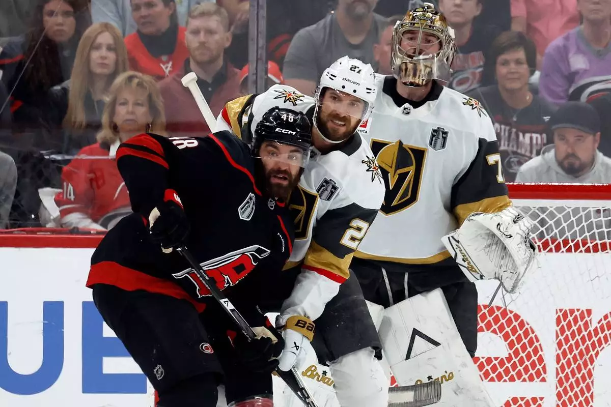 Carolina Hurricanes' Jordan Martinook (48) battles for position with Vegas Golden Knights' Shea Theodore (27) in front of goaltender Carter Hart (79) during the first period in Game 2 of the NHL hockey Stanley Cup Final series in Raleigh, N.C., Thursday, June 4, 2026. (AP Photo/Karl DeBlaker)