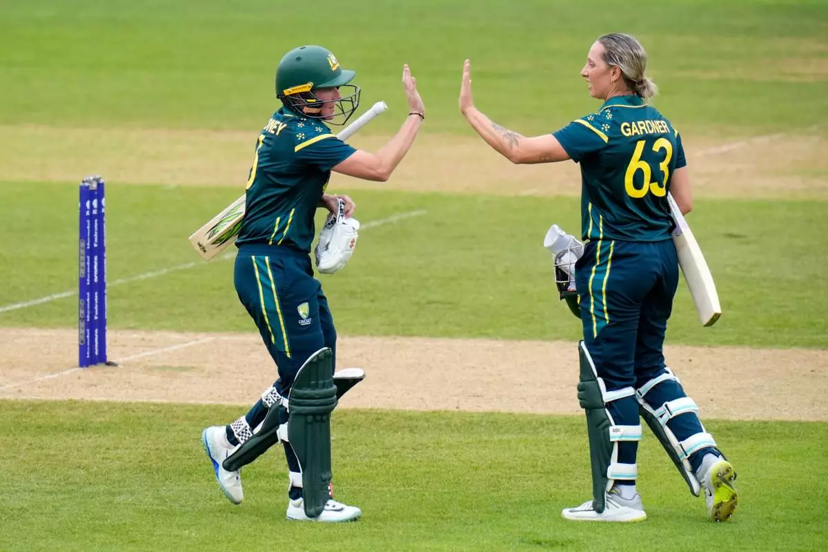 Beth Mooney, left, and Ashleigh Gardner of Australia celebrate a 100 partnership during the Women's T20 World Cup match between Australia and Netherlands in Southampton, England, Saturday June 20, 2026. (Andrew Matthews/PA via AP)