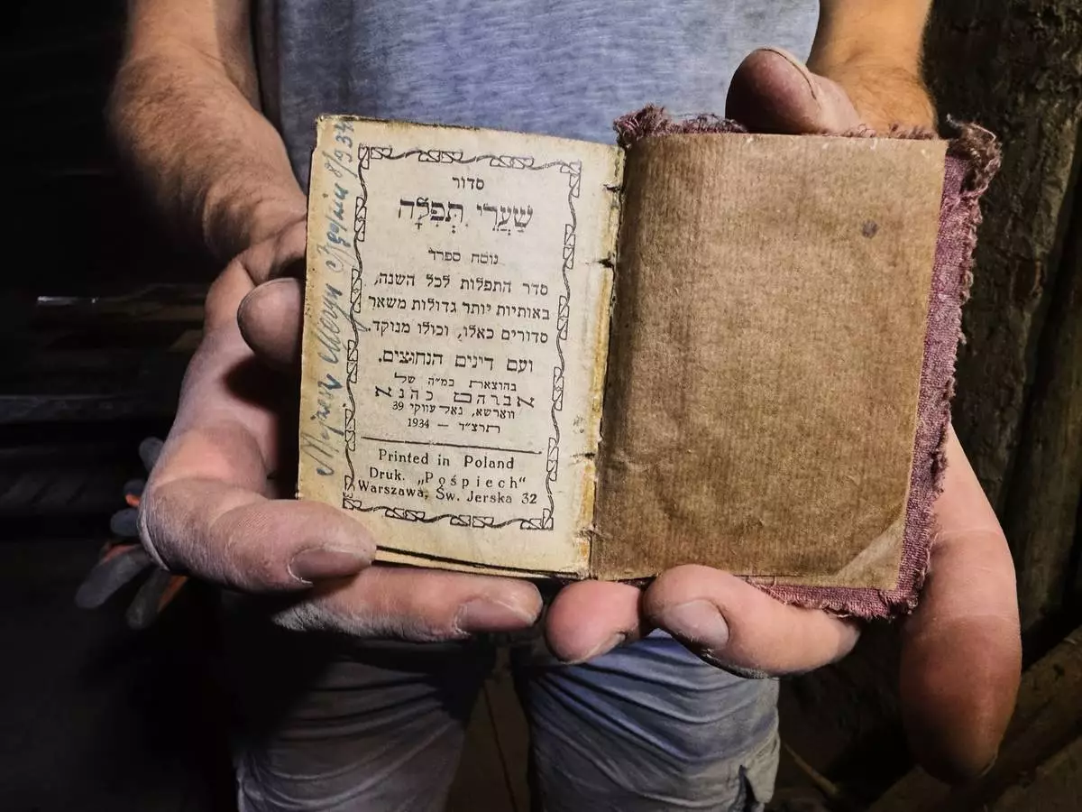 Wojciech Mazan, museologist and art historian shows a Hebrew prayer book from 1934, found in the attic of the "Bedzin Ghetto Fighters Memorial" house in Bedzin, Poland, on May 29, 2026. (AP Photo/Rafal Niedzielski)