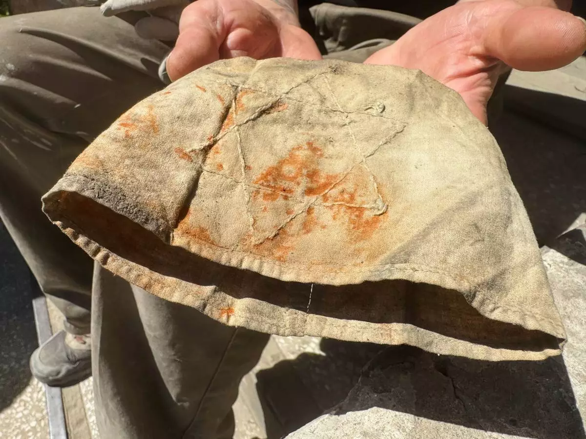Marcin Dos, a volunteer at the Cukerman Gate Foundation, presents an armband with the Star of David, which he found in the dust from the attic of the "Bedzin Ghetto Fighters Memorial" house in Bedzin, Poland, on May 29, 2026. (AP Photo/Rafal Niedzielski)