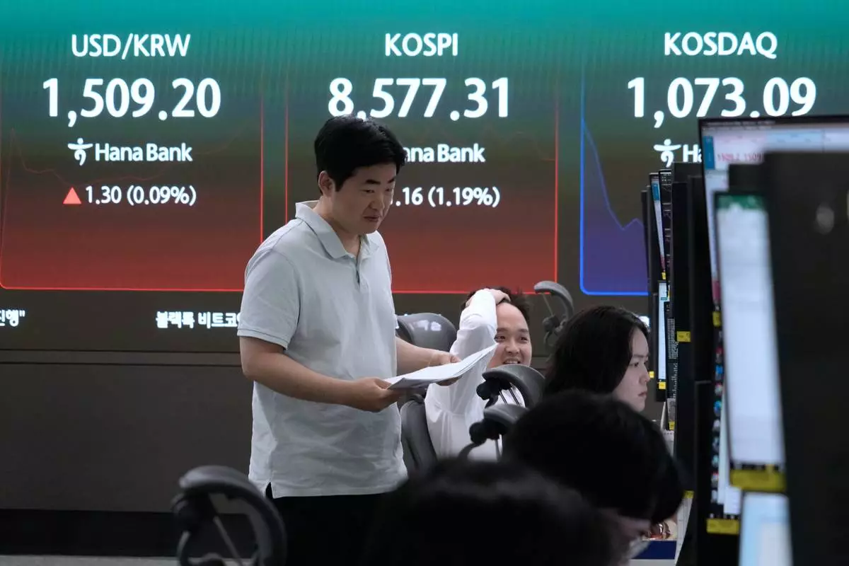 Currency traders work near a screen showing the Korea Composite Stock Price Index (KOSPI) and the foreign exchange rate between U.S. dollar and South Korean won at the foreign exchange dealing room of the Hana Bank headquarters in Seoul, South Korea, Monday, June 1, 2026. (AP Photo/Ahn Young-joon)