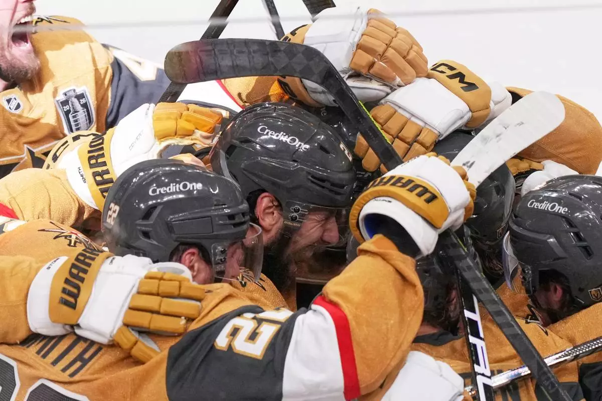 Vegas Golden Knights defenseman Shea Theodore, center, celebrates his goal with teammates in the second overtime in Game 3 of the NHL hockey Stanley Cup Final series against the Carolina Hurricanes, Saturday, June 6, 2026, in Las Vegas. (AP Photo/Candice Ward)