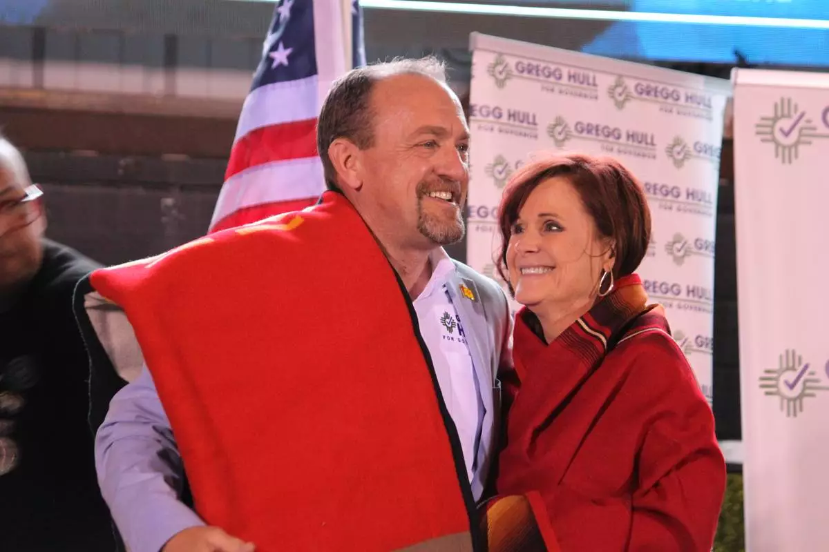 Republican gubernatorial nominee Gregg Hull and his wife Carrie are wrapped in Pendleton blankets gifted to them by Native American supporters during an Election Night watch party in Albuquerque, New Mexico, on Tuesday, June 2, 2026. (AP Photo/Susan Montoya Bryan)