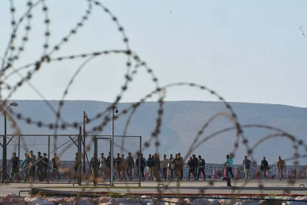 FILE - Migrants rescued south of Crete walk after their arrival at the the port of Lavrio, Greece, on July 10, 2025. (AP Photo/Petros Giannakouris, File)