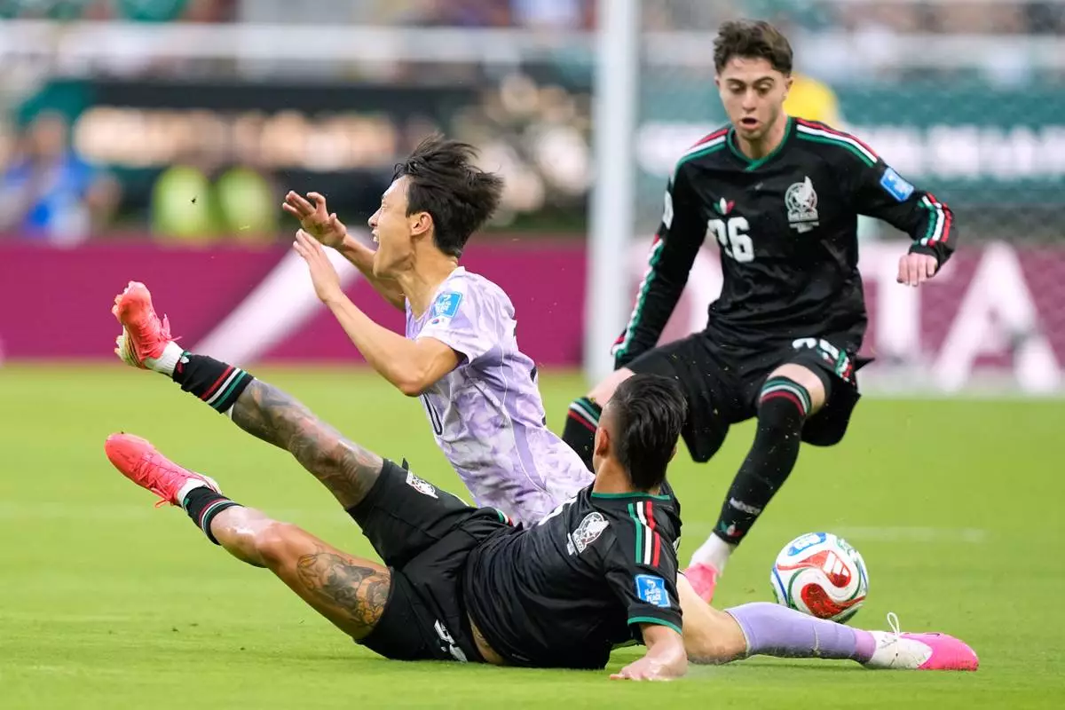 South Korea's Lee Jae-sung (10) reacts as he is tackled by Mexico's Roberto Alvarado (25) during the World Cup Group A soccer match between Mexico and South Korea in Zapopan, near Guadalajara, Mexico, Thursday, June 18, 2026. (AP Photo/Natacha Pisarenko )