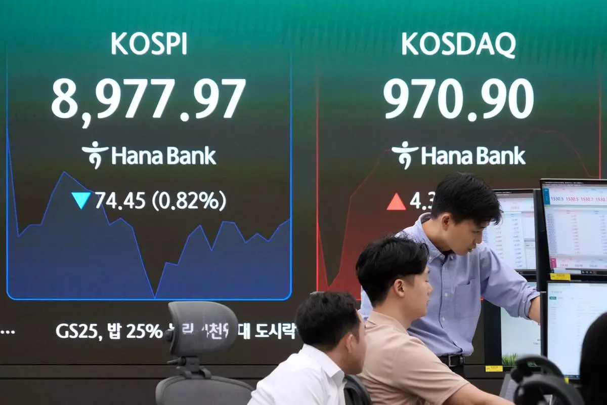 Currency traders watch monitors near a screen showing the Korea Composite Stock Price Index (KOSPI) at the foreign exchange dealing room of the Hana Bank headquarters in Seoul, South Korea, Monday, June 22, 2026. (AP Photo/Ahn Young-joon)