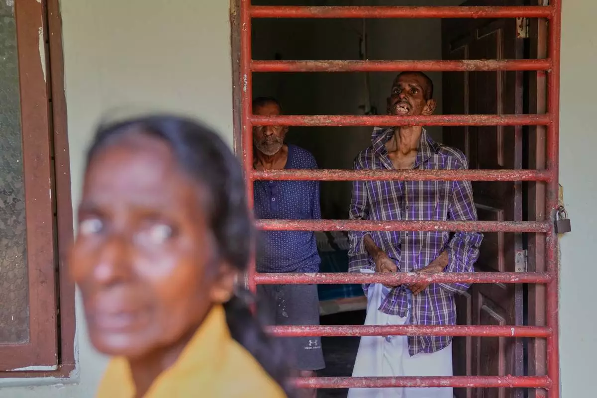 The mother of a resident stands outside a dormitory at a nursing home, where inmates of another nursing home that caught fire on Wednesday are being temporarily housed in Anguruwatota, Sri Lanka, Friday, June 5, 2026. (AP Photo/Eranga Jayawardena)